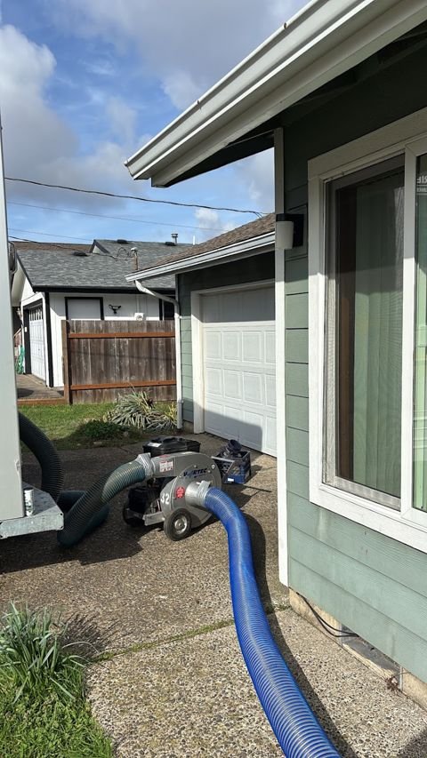Blowing machine set up in the driveway, hose run to the attic hatch